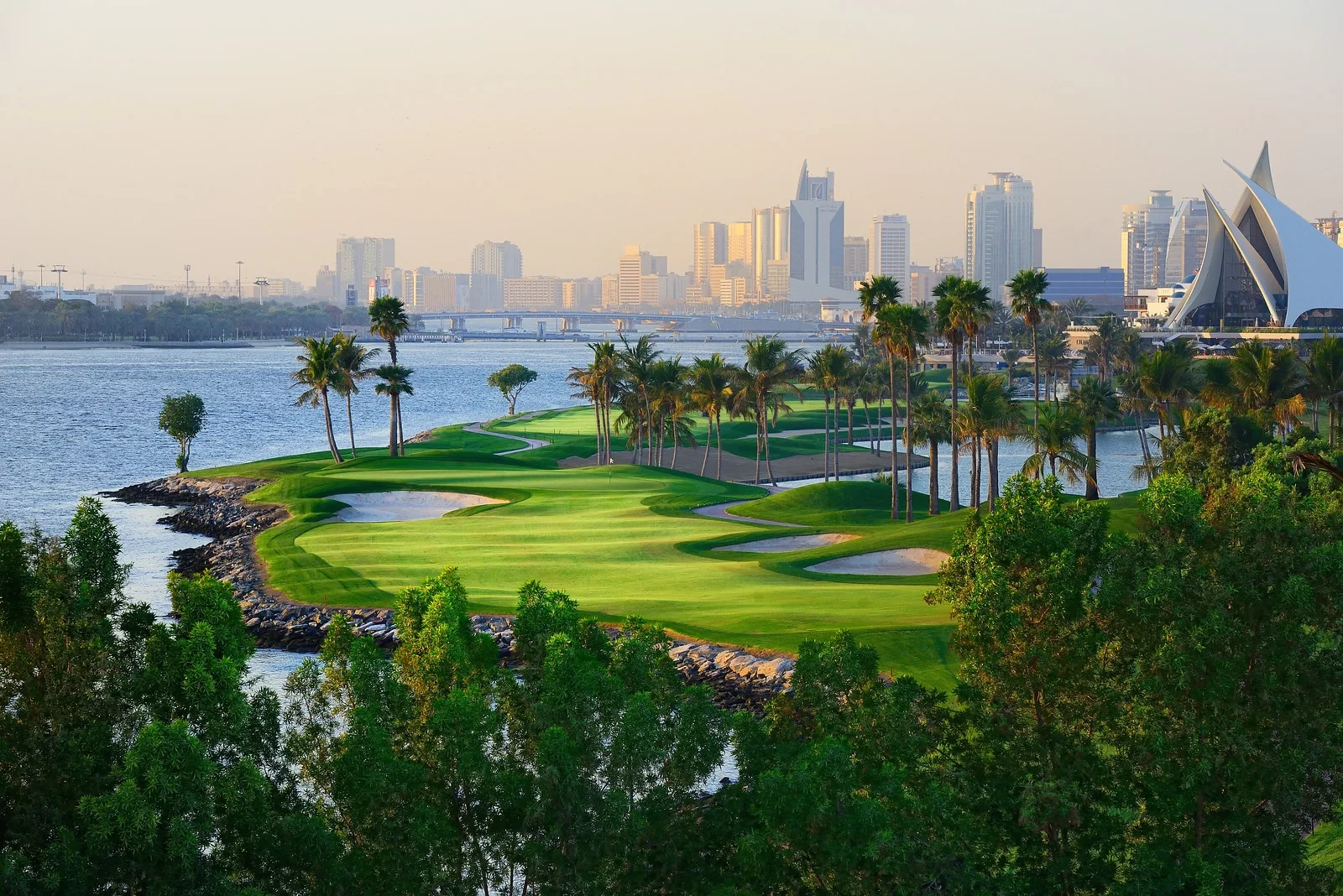 Scenic view of Dubai Creek Golf & Yacht Club, lush greens, skyline backdrop.