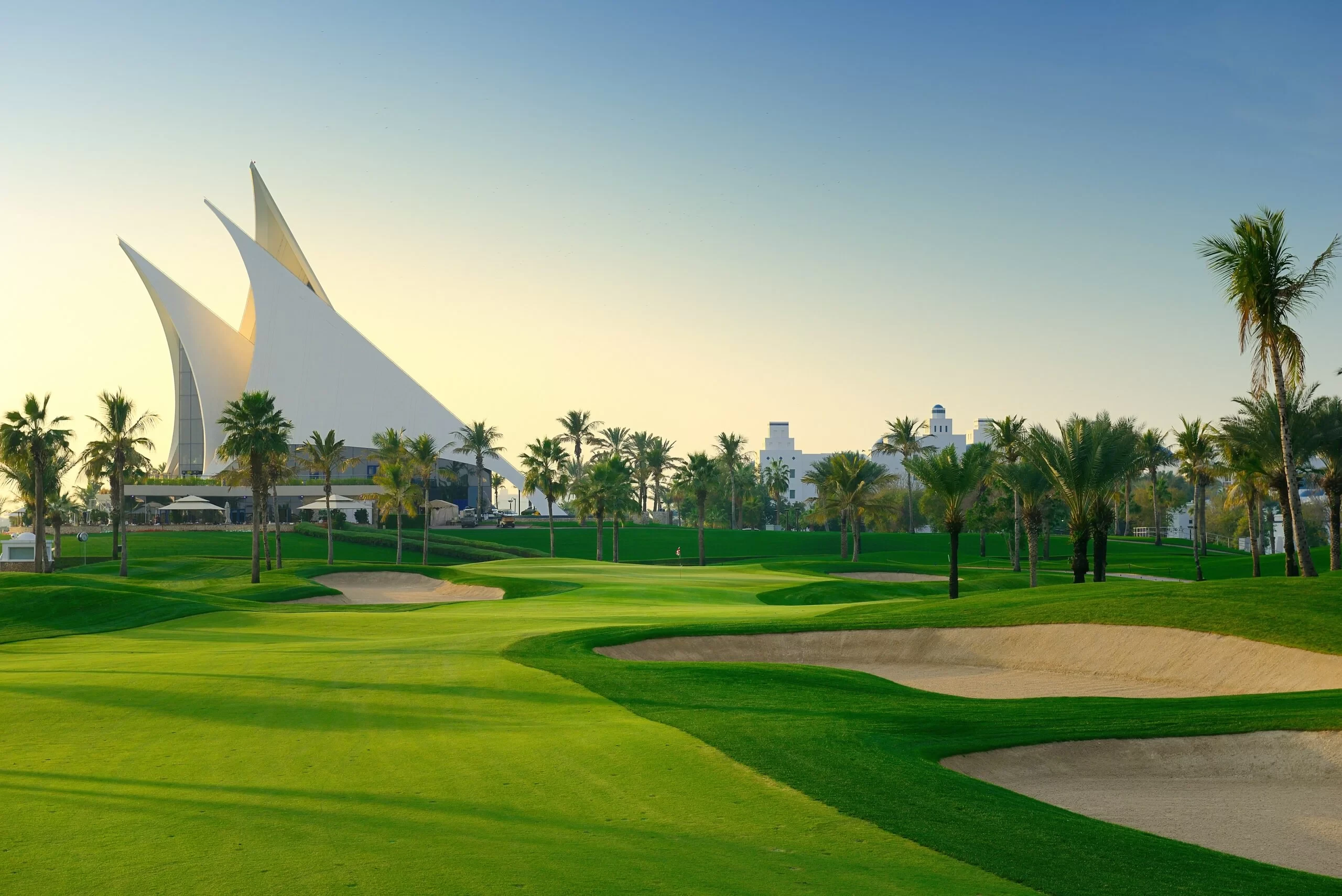 Dubai Creek Golf & Yacht Club lush green course, palm trees.