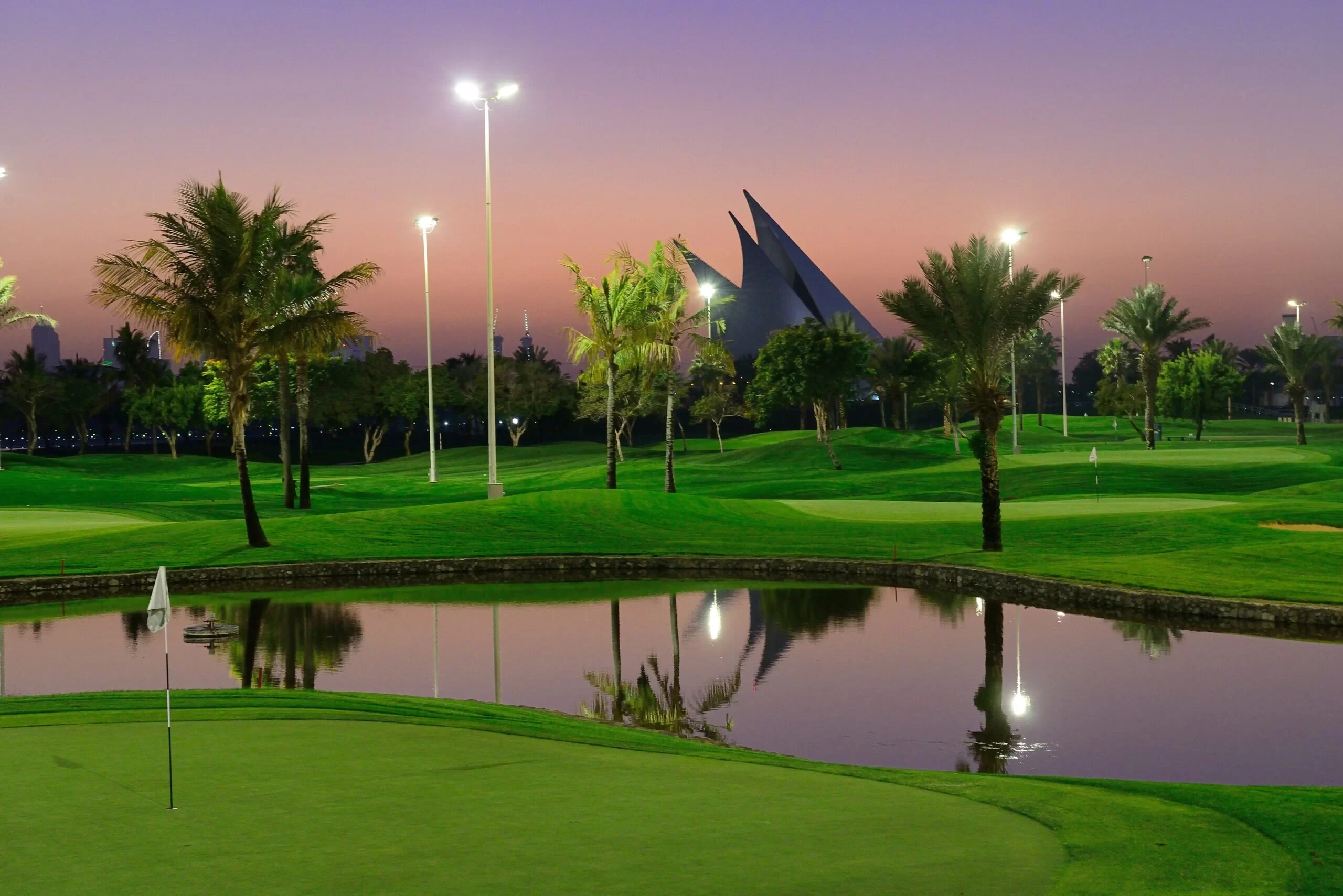 Dubai Creek Golf & Yacht Club at sunset, lush greens and water.