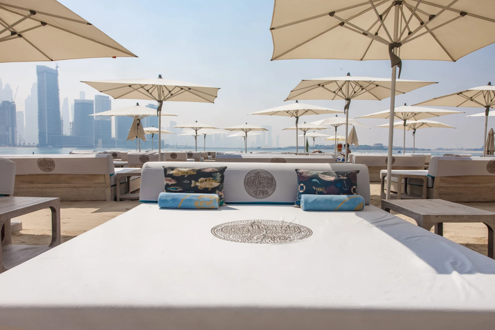 Gallery 7/40 Dubai beach seating with umbrellas and skyline view.