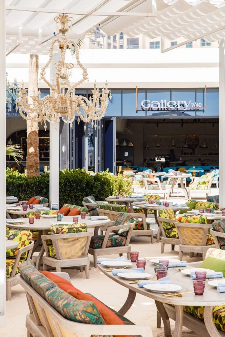 Outdoor seating at Gallery 7/40 Dubai with chandelier and colorful cushions.