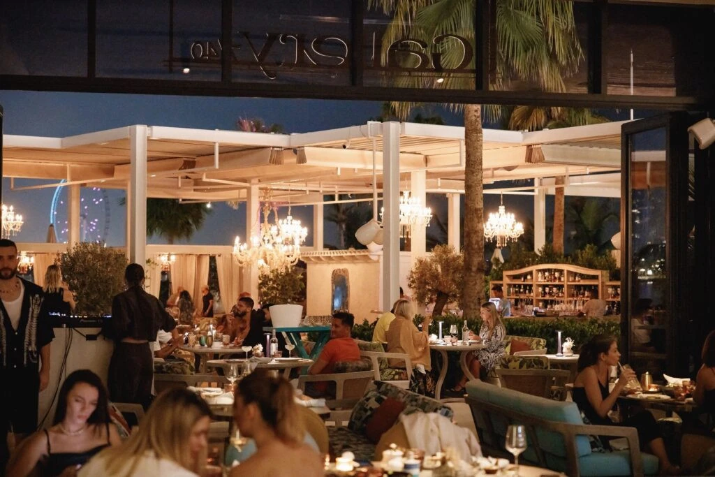 Elegant dining at Gallery 7/40 Dubai with chandeliers and greenery.