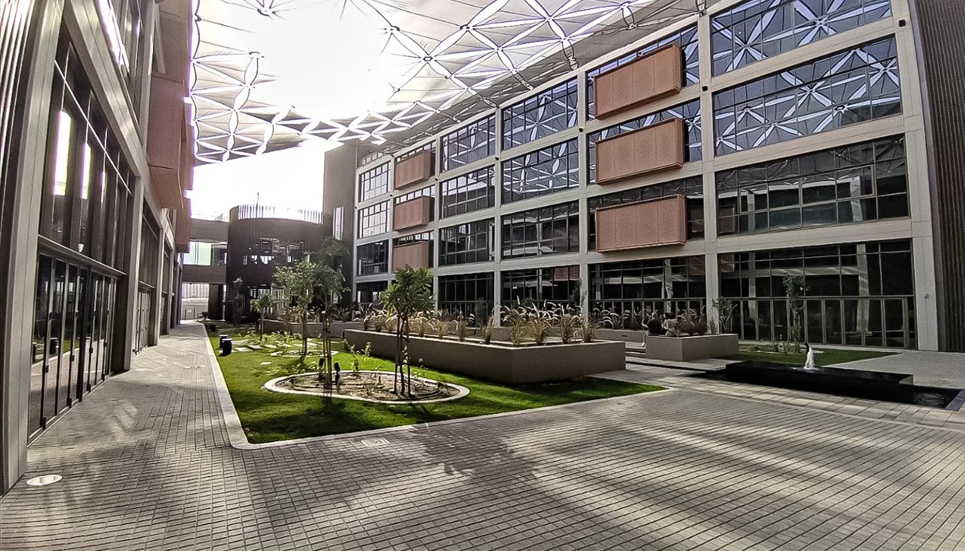 University of Birmingham Dubai courtyard with modern architecture and greenery.