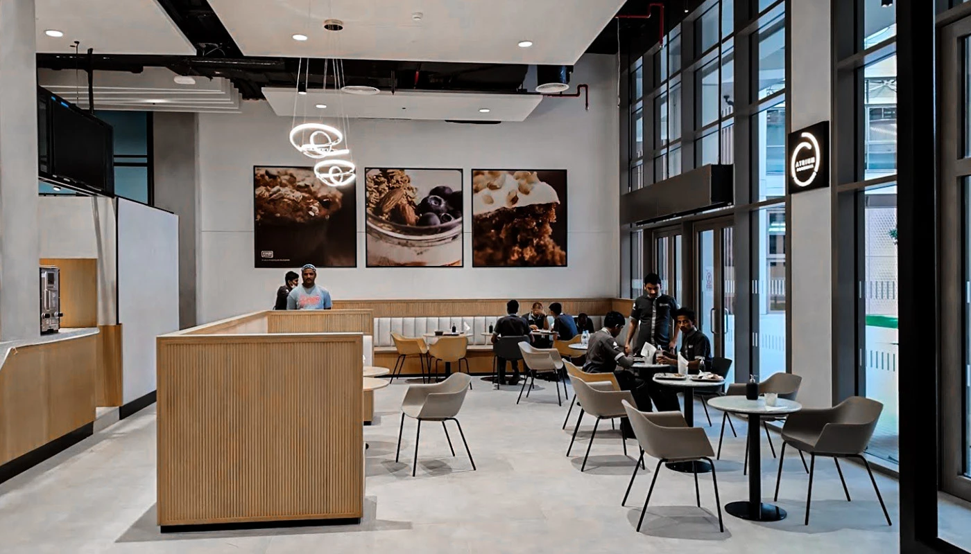 Modern cafe at University of Birmingham Dubai with seated students.