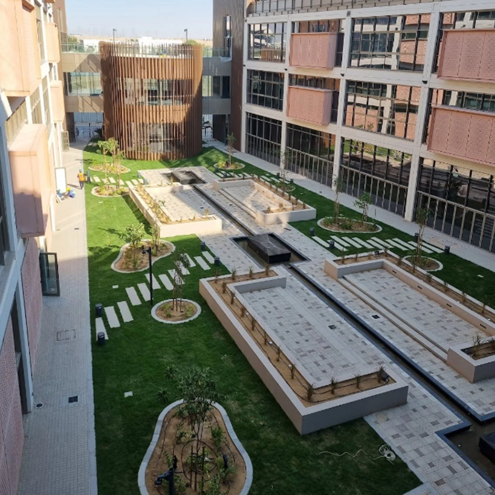 University of Birmingham Dubai courtyard with modern architecture and green spaces.