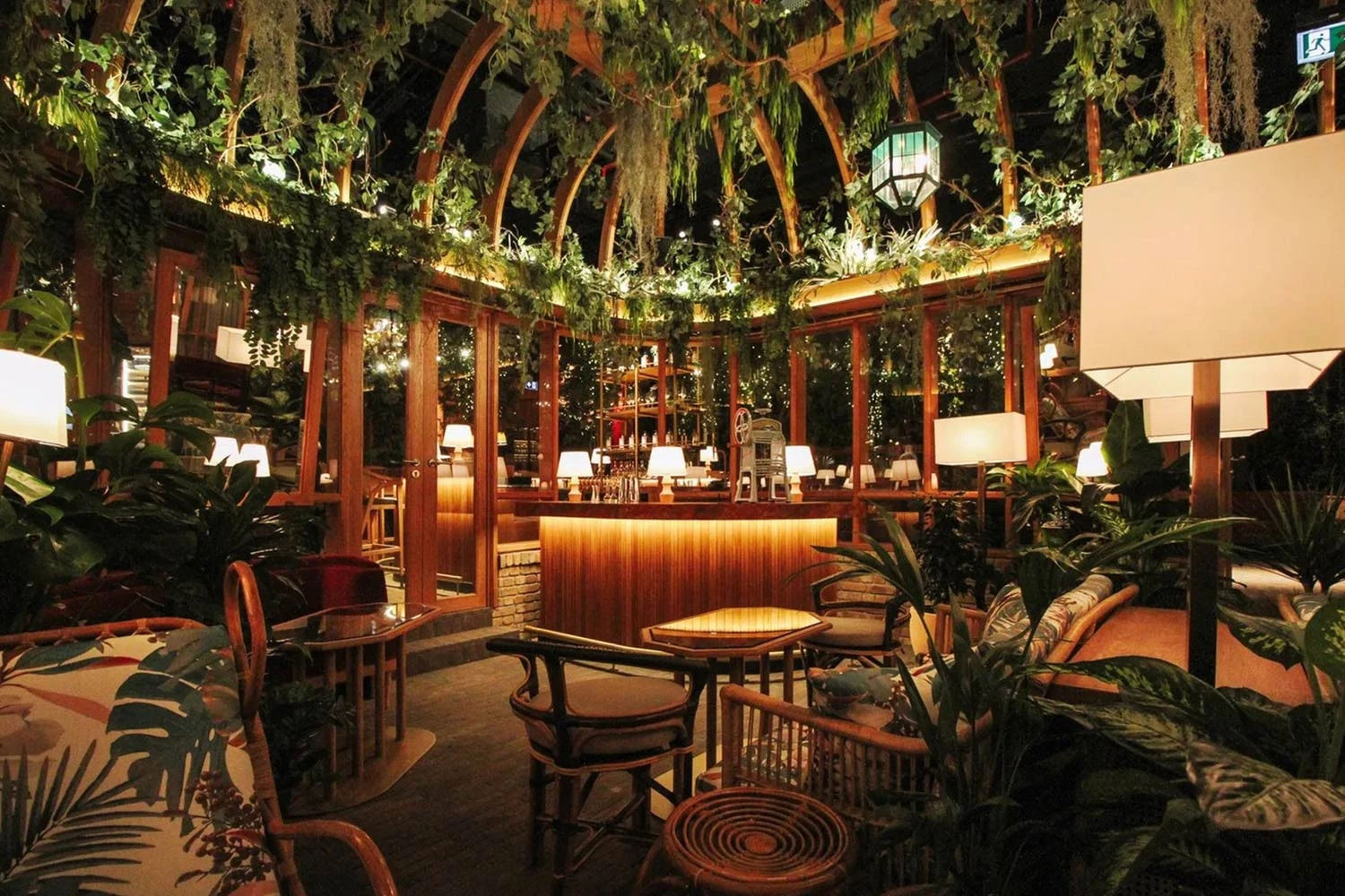 Lush indoor seating area at The Guild Dubai with plants and lights.