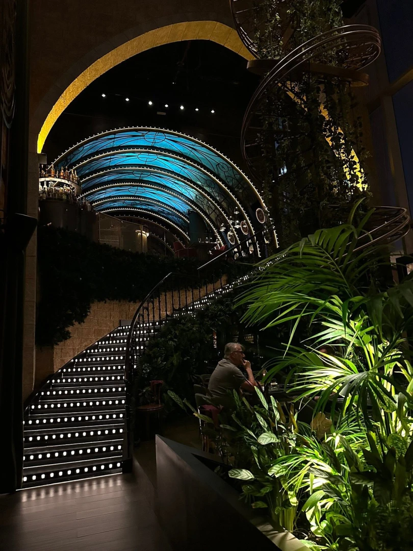 Amelia Restaurant & Lounge, Dubai, elegant spiral staircase with lush greenery.