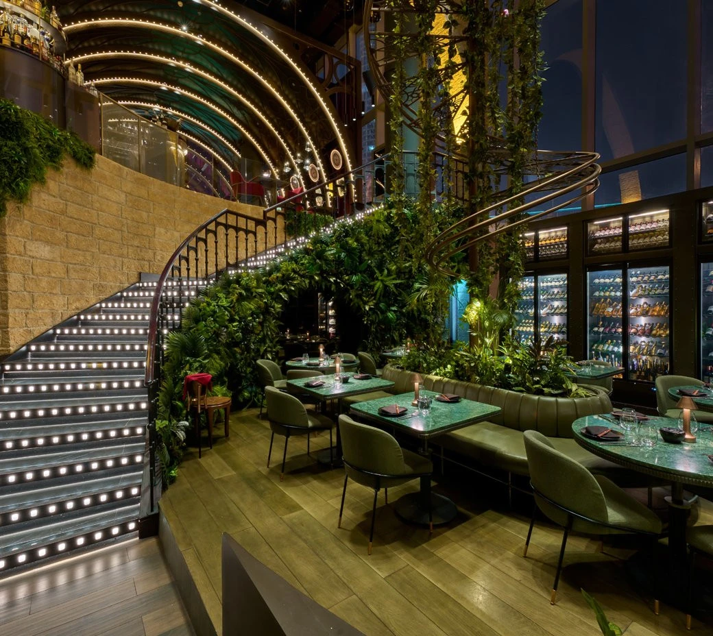 Elegant dining area at Amelia Restaurant & Lounge, Dubai with lush greenery.