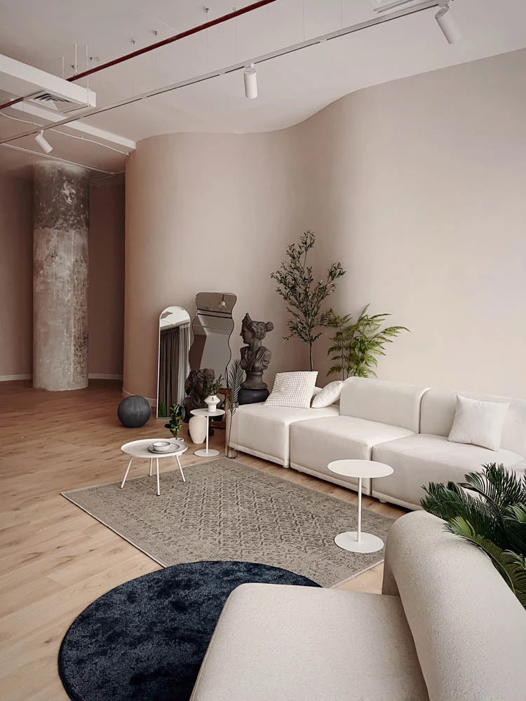 Modern lounge area at LUMA Studio, Dubai with white sofas and plants.