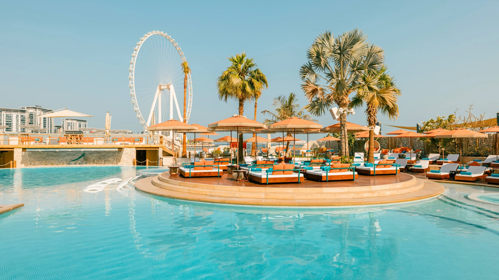 Bla Bla Dubai poolside with loungers and Dubai Eye view.