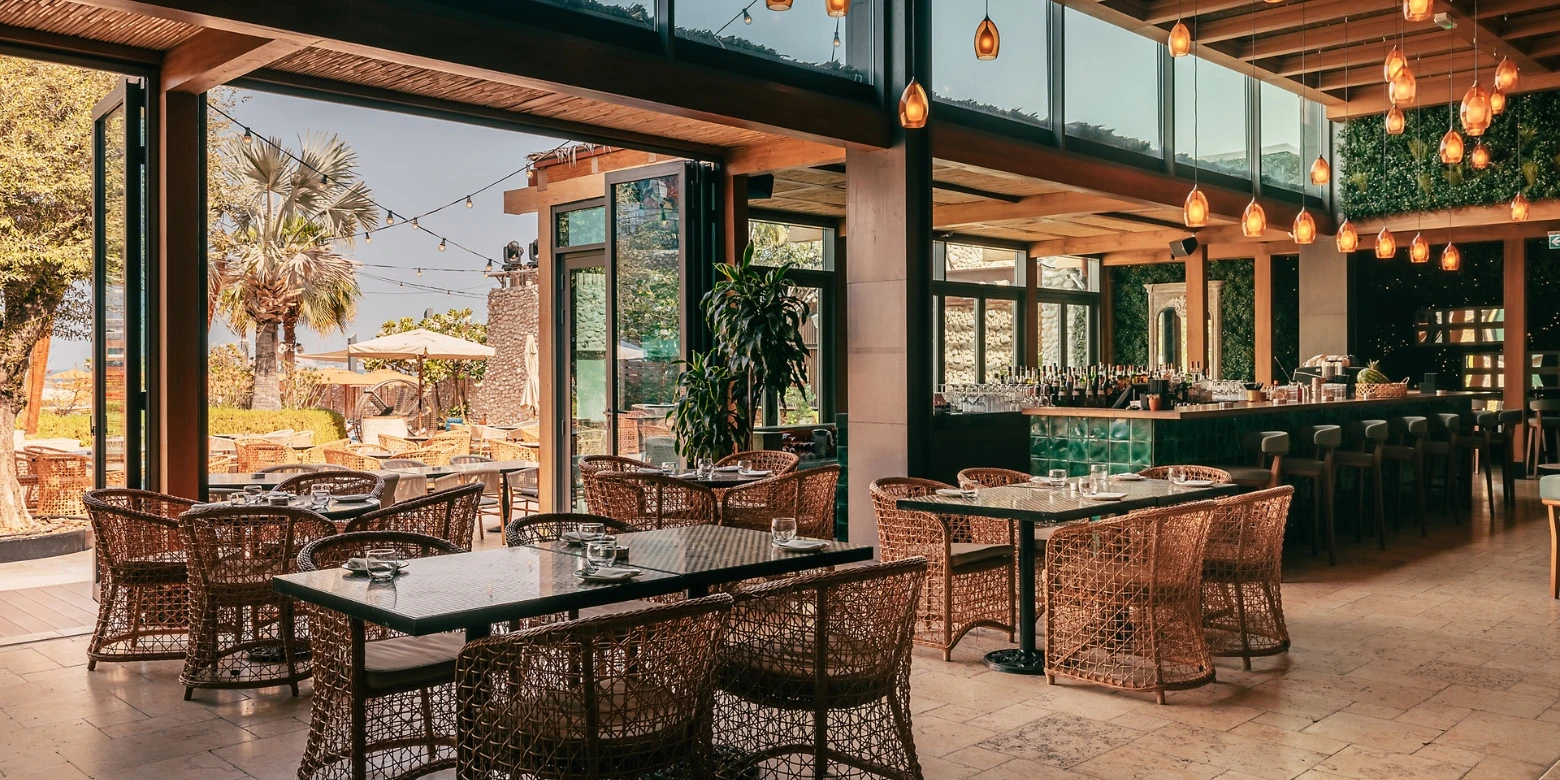 Bla Bla Dubai restaurant interior with wicker chairs and outdoor view.