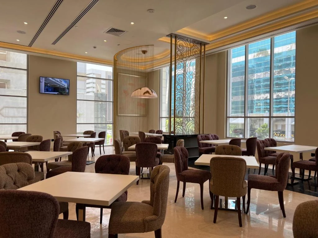 Elegant dining area at Khalidia Palace Hotel Dubai with large windows.