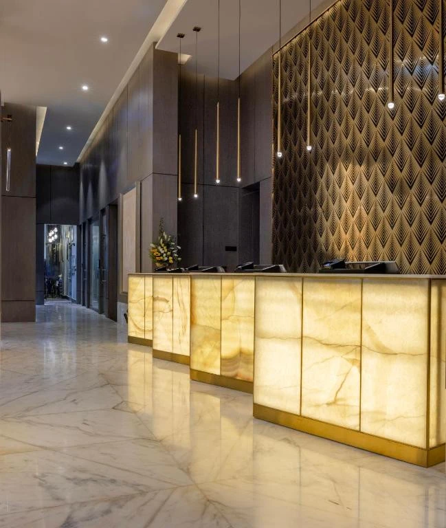 Elegant lobby at Khalidia Palace Hotel Dubai with illuminated reception desk.