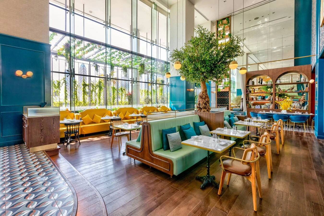 Bright interior with green seating at Couqley Brasserie, Dubai.