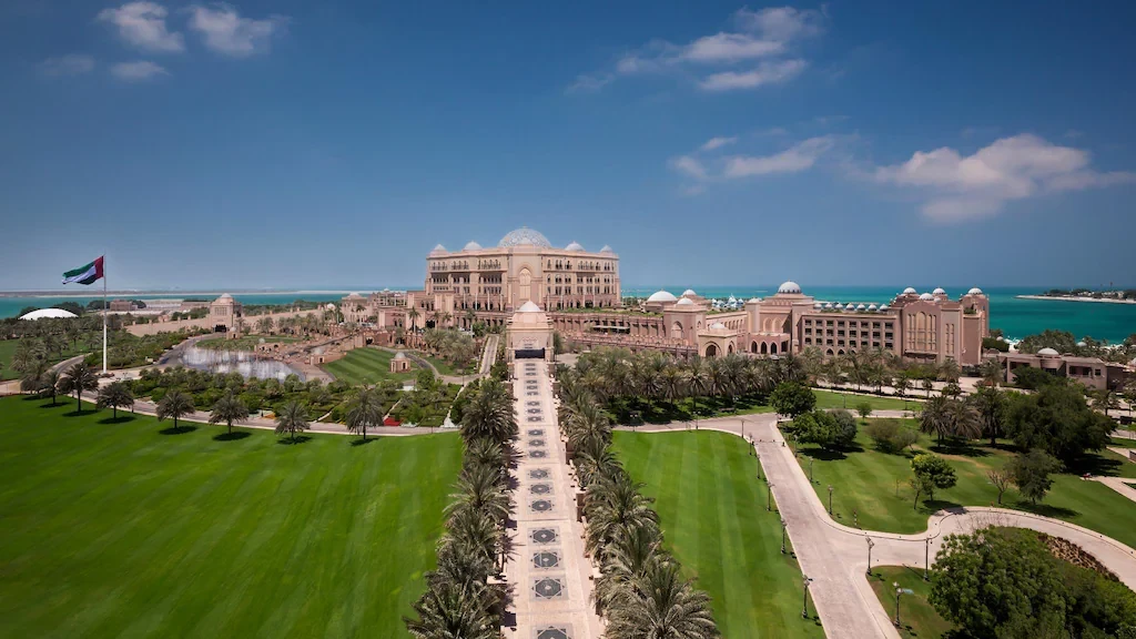 Emirates Palace Mandarin Oriental, Abu Dhabi, lush gardens, and blue sea.