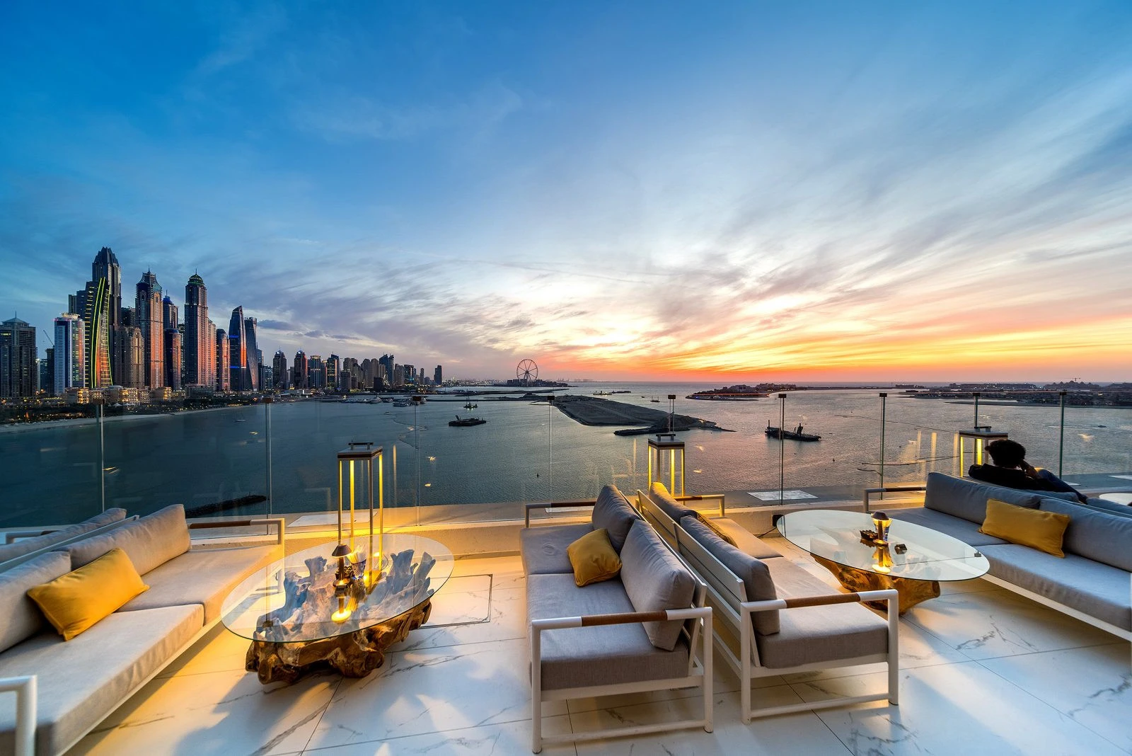 Sunset view from The Penthouse Dubai rooftop lounge, overlooking city skyline.