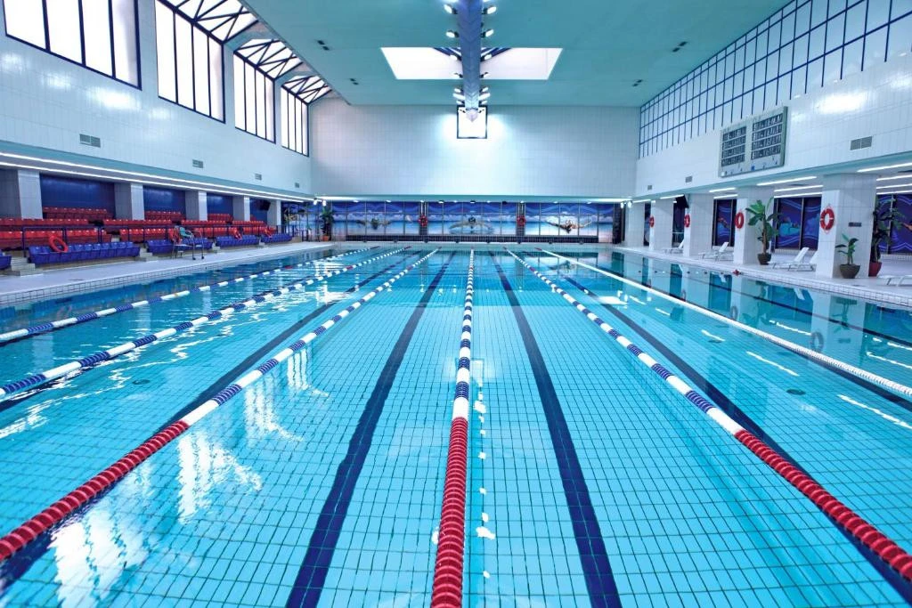 Indoor swimming pool at Erth Hotel Abu Dhabi, spacious and well-lit.