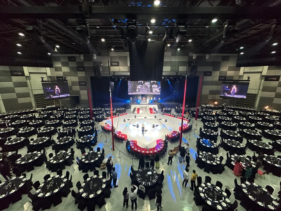 The Agenda Dubai event venue with round tables and stage setup.