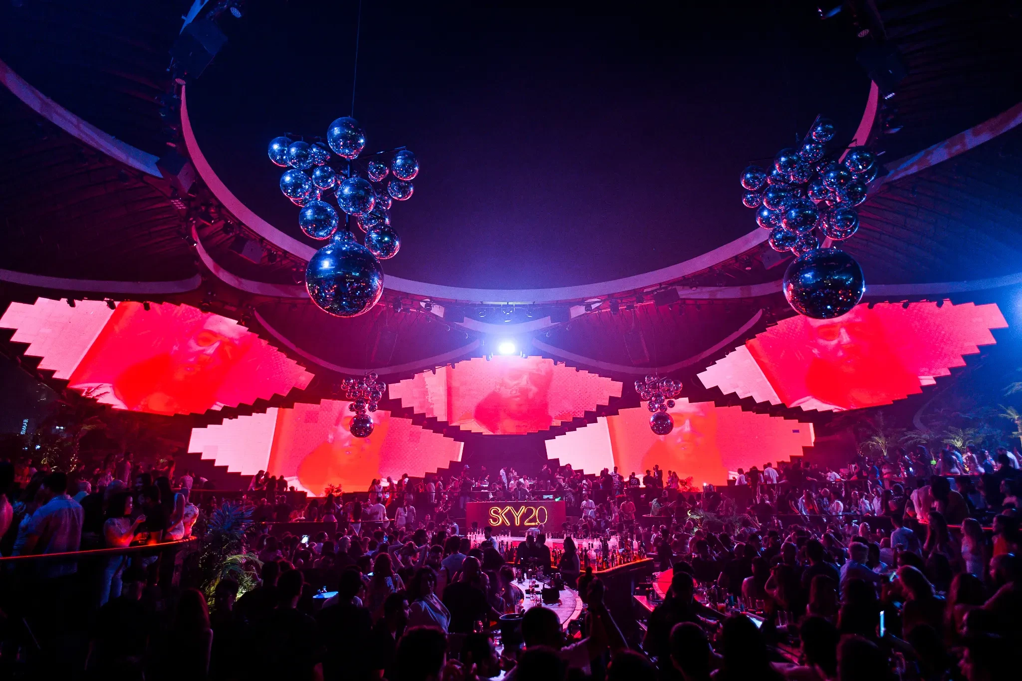 Vibrant nightclub interior at Sky2.0 Dubai with colorful lights and crowd.