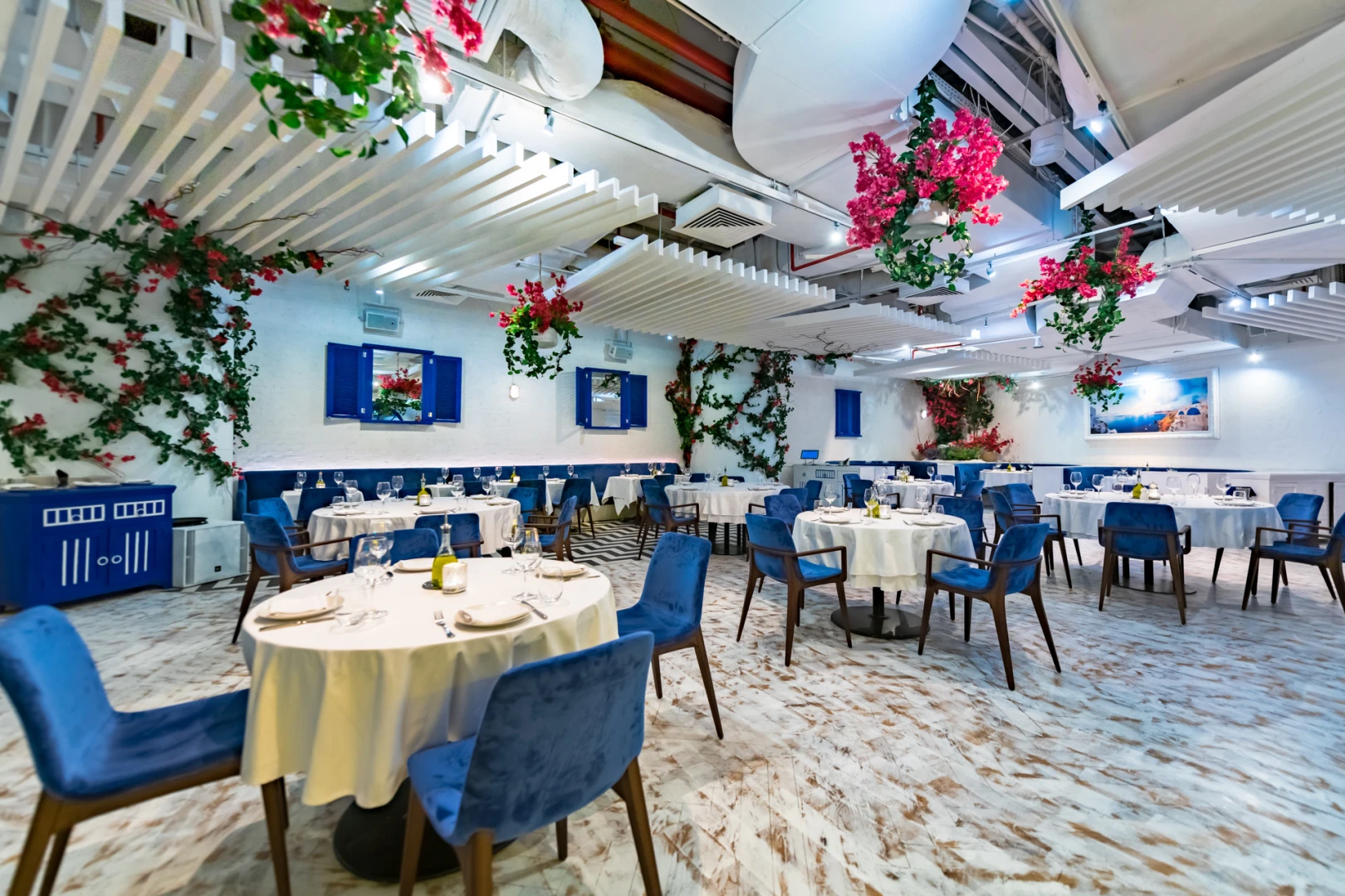 Elegant dining area with blue chairs at Opa Dubai.