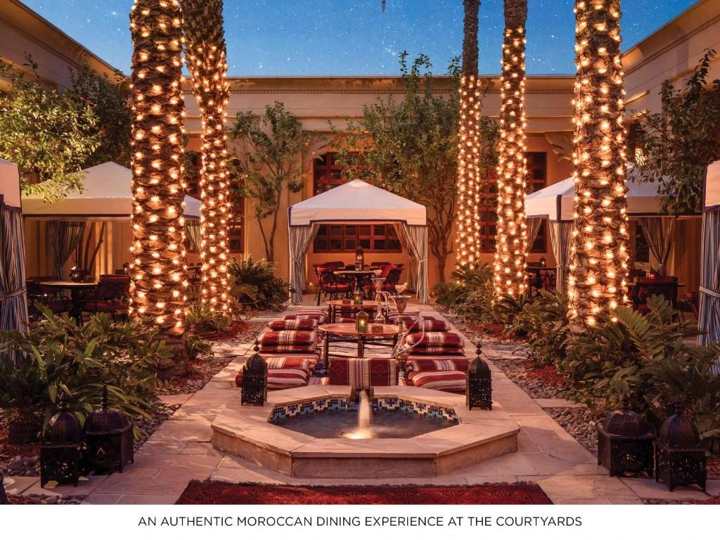 Elegant courtyard dining at One&Only Royal Mirage, Dubai, with lit palm trees.