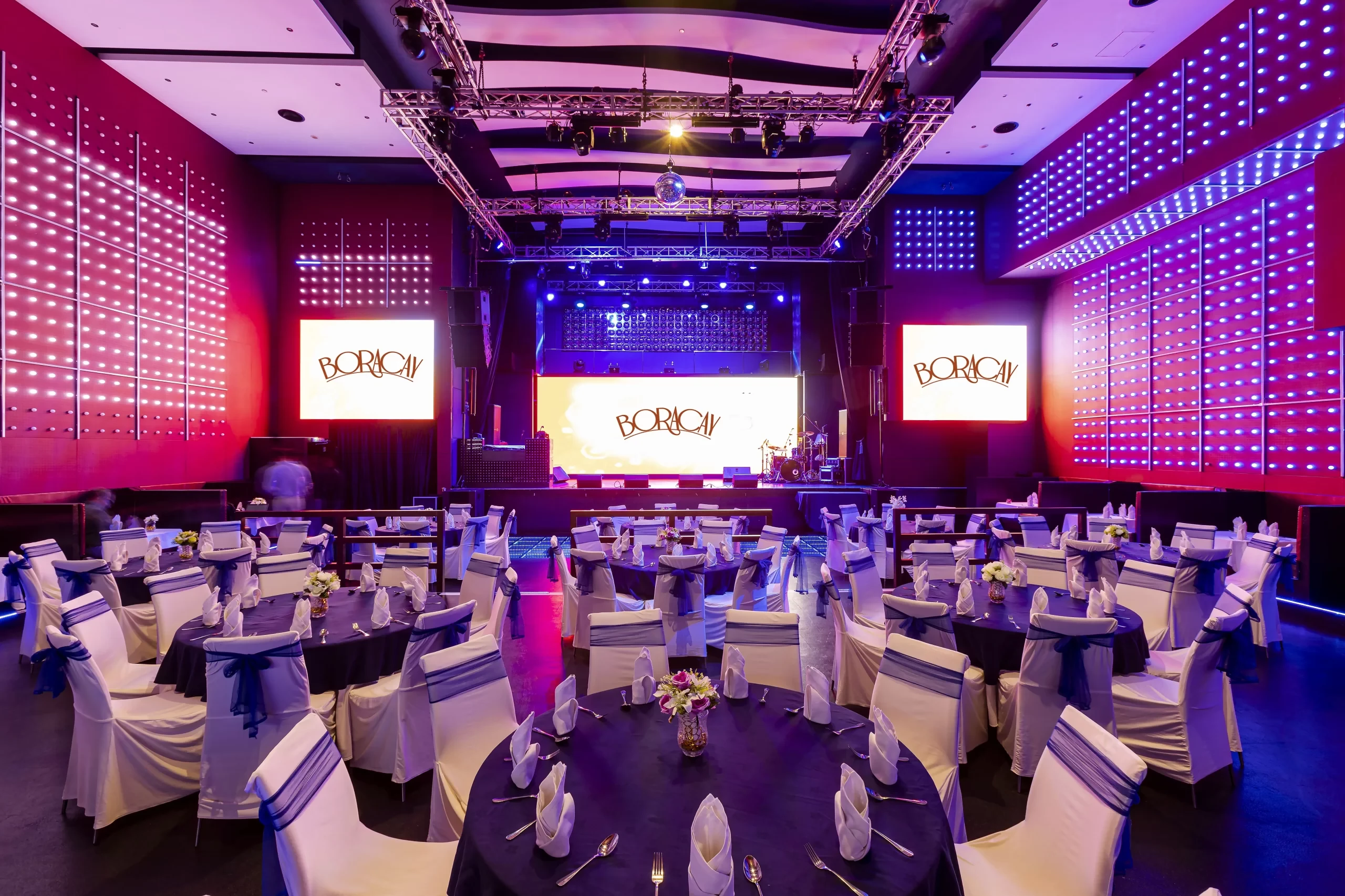 Boracay Night Club Dubai, elegant tables, vibrant lighting, stage setup.