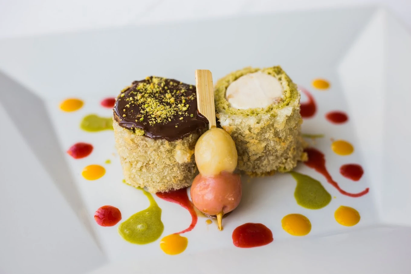 Gourmet dessert with colorful sauces at Atelier M, Dubai.