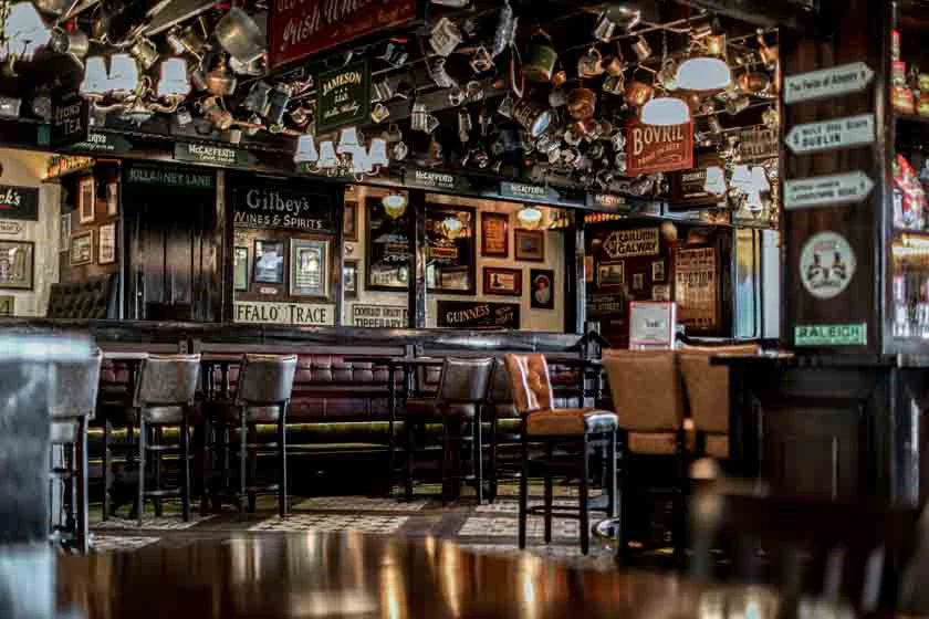 Traditional pub interior with hanging mugs and framed artwork, Dubai.