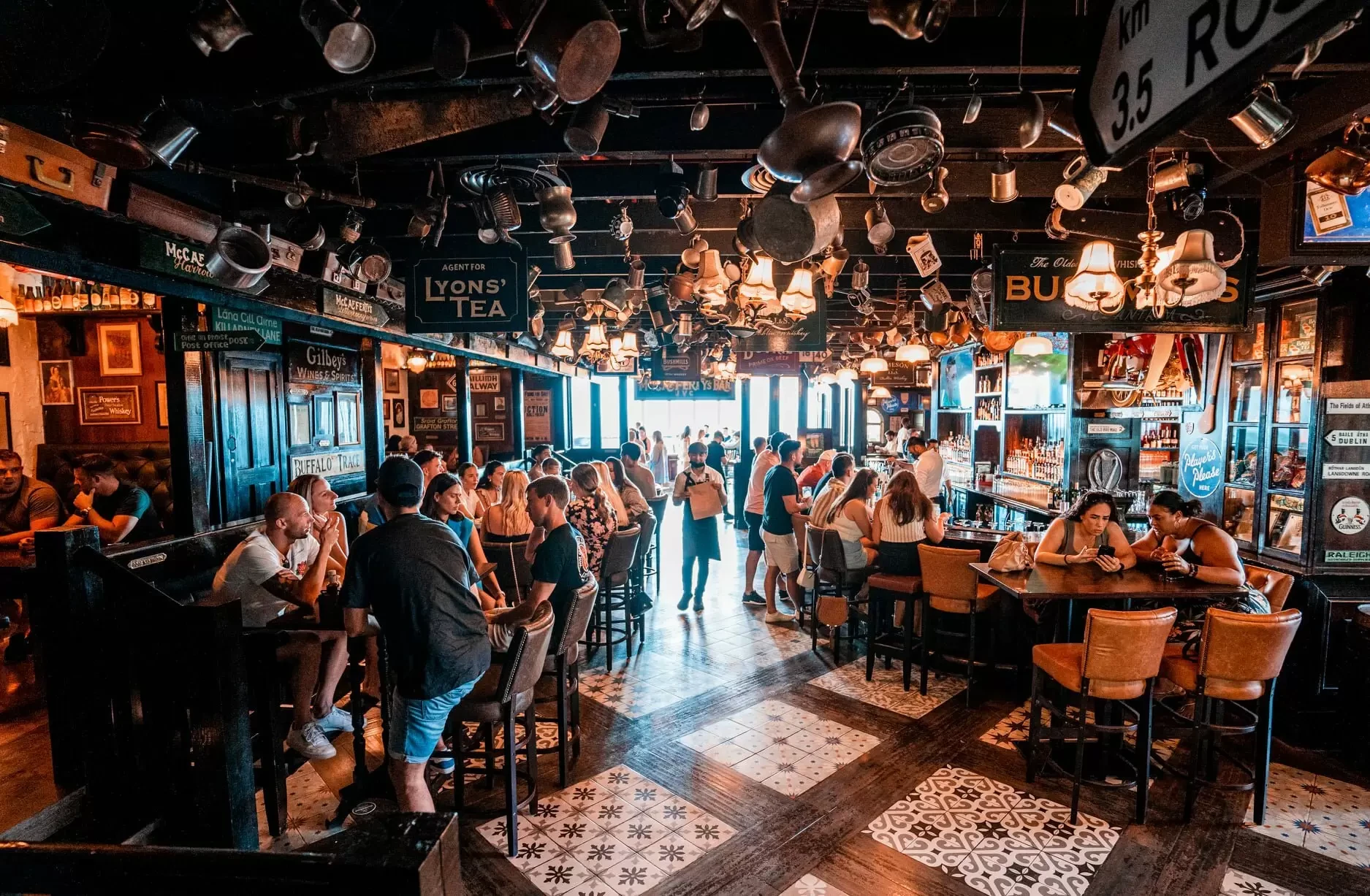 Crowded McCafferty's Pub Jumeirah Village, Dubai, lively atmosphere, patrons socializing.