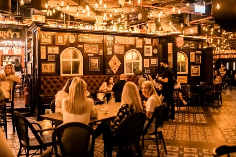 Cozy interior of McCafferty's Pub Jumeirah Village, Dubai, with patrons dining.