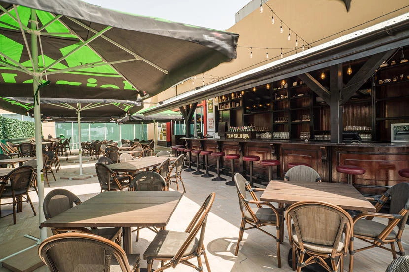 Outdoor seating at McCafferty's Pub Jumeirah Village, Dubai, with umbrellas.