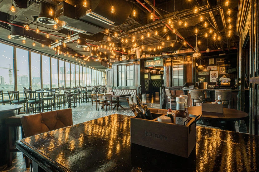 Cozy interior of McCafferty's Pub Jumeirah Village, Dubai with warm lighting.