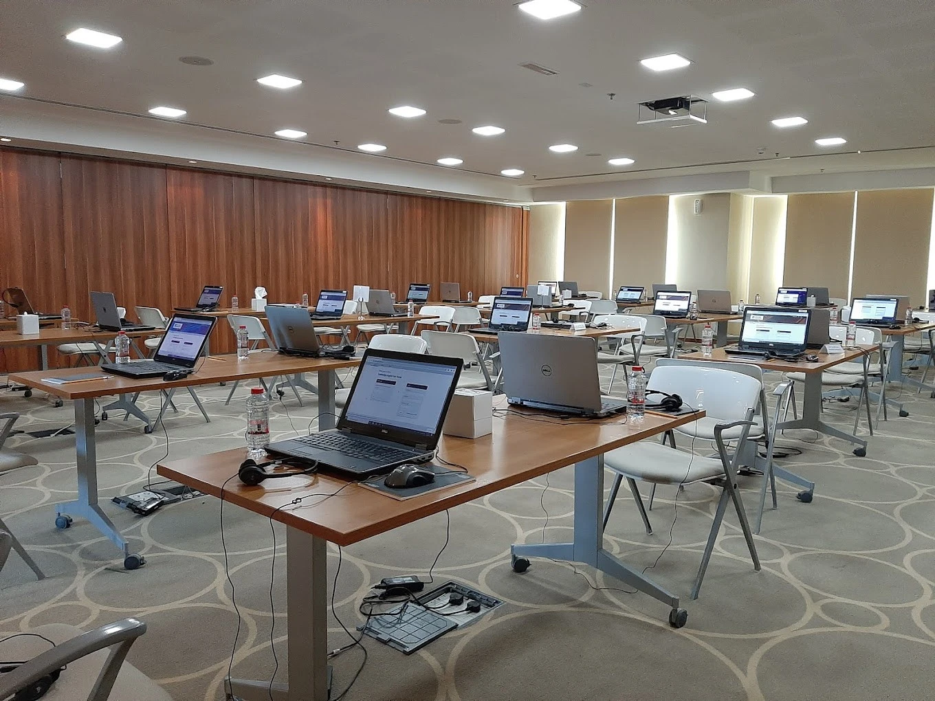Conference Hall Dubai Knowledge Park with laptops on tables, empty chairs.