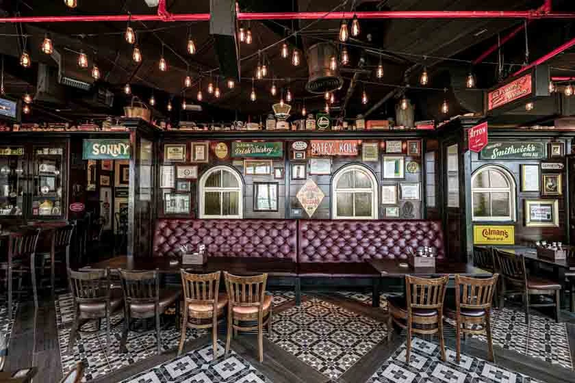 Vintage-style pub interior with leather seating and framed memorabilia, Dubai.