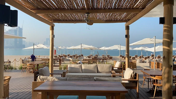 Beachfront seating at Surf Club Dubai with ocean view.