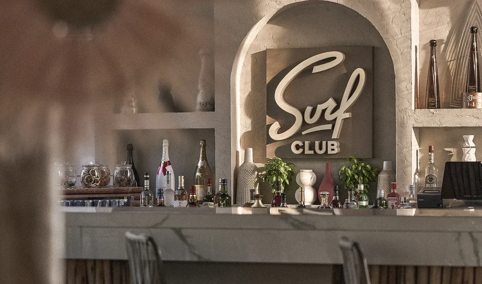 Surf Club Dubai bar with bottles and decorative elements.