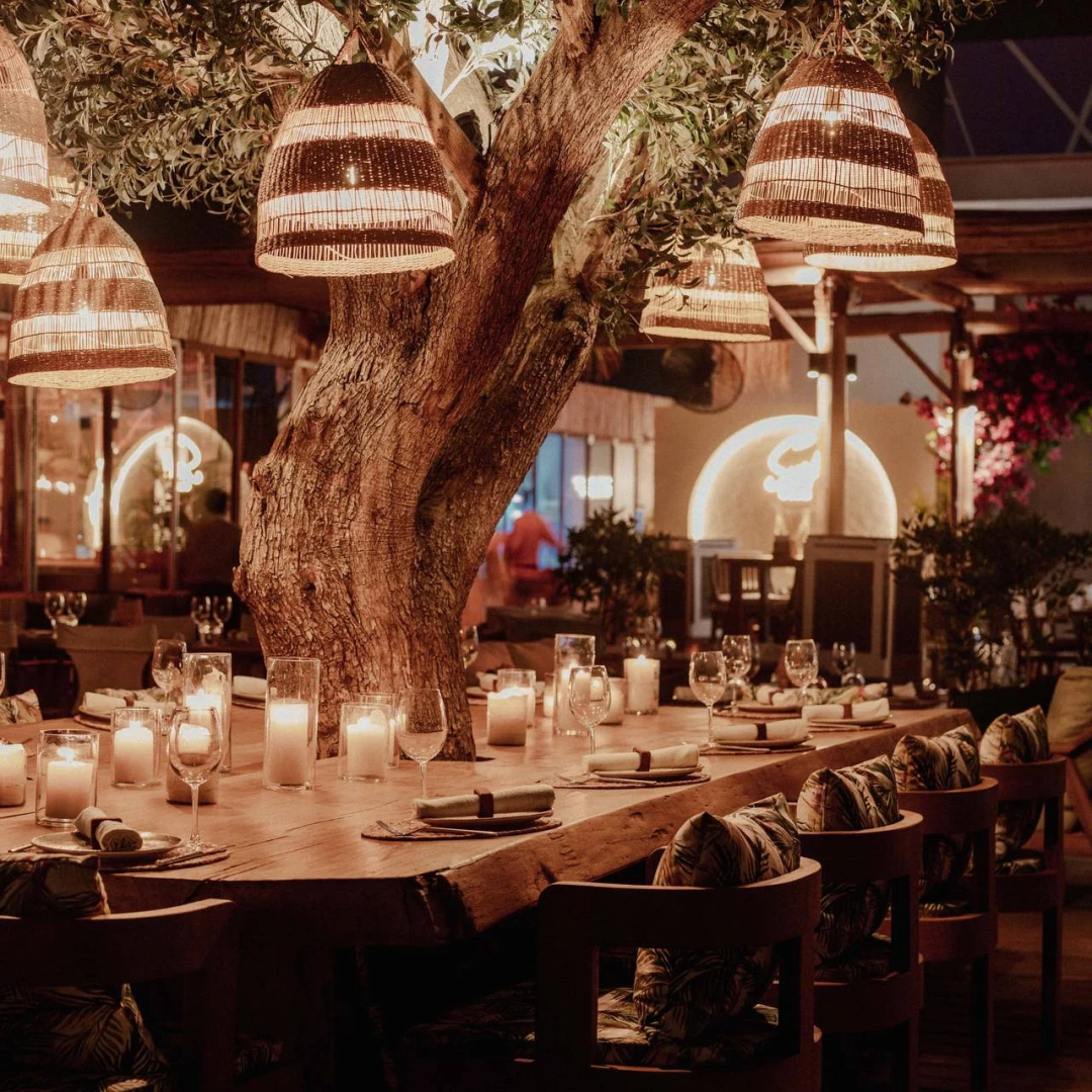 Candlelit dining table under tree at Surf Club Dubai.