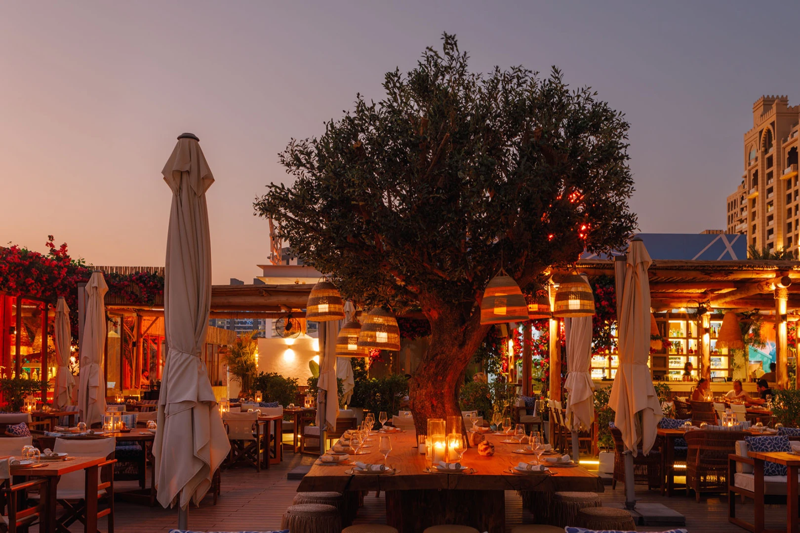 Outdoor dining area at Surf Club Dubai during sunset.