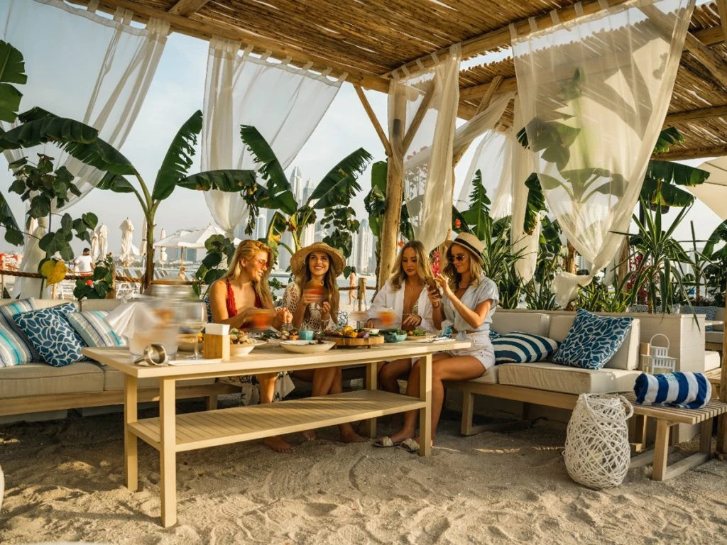 Group enjoying brunch at Surf Club Dubai beachside cabana.