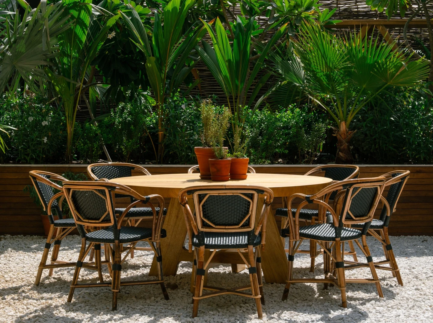 Outdoor seating at Eugène Eugène Restaurant, Dubai with lush greenery.