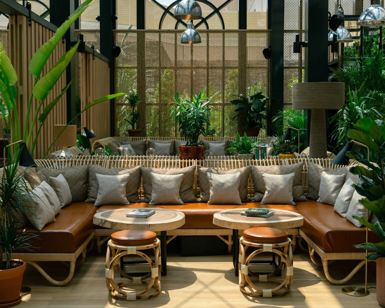 Eugène Eugène Restaurant Dubai, cozy seating with plants and cushions.
