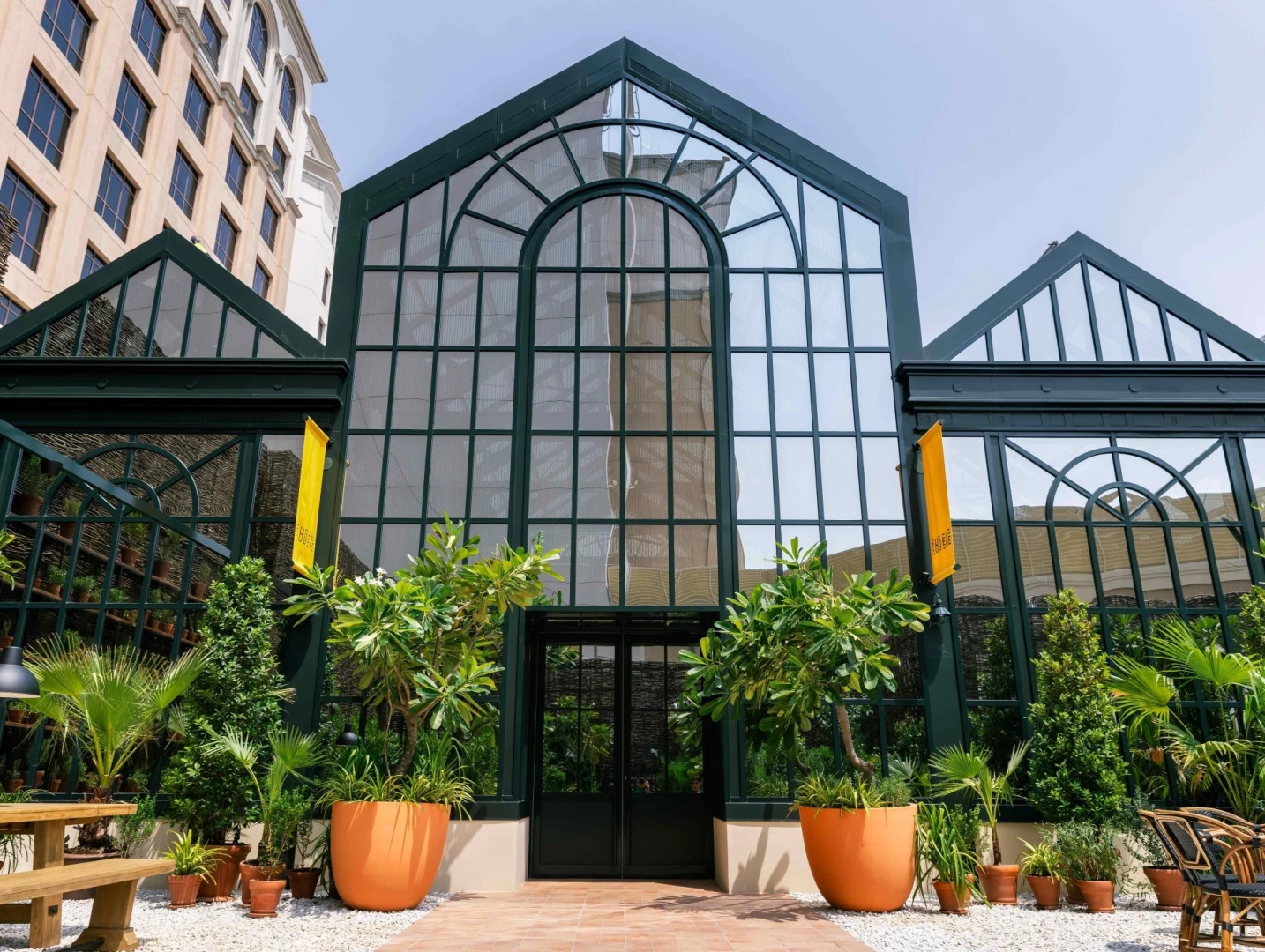 Eugène Eugène Restaurant Dubai entrance with glass facade and plants.