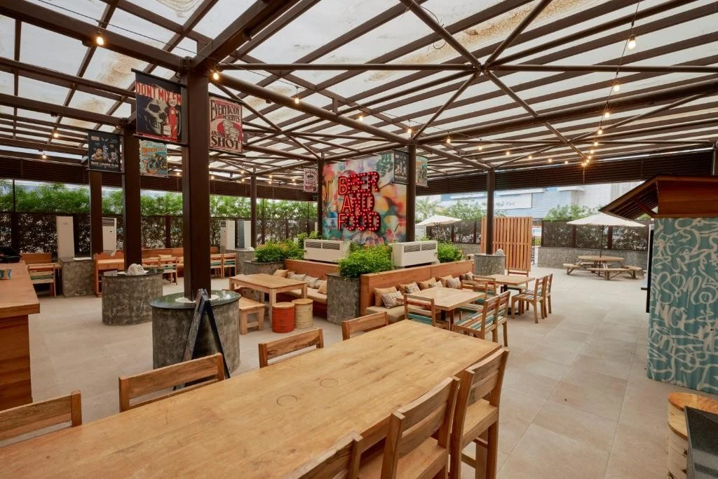 Covered outdoor terrace with wooden tables, Citymax Hotel Business Bay, Dubai.