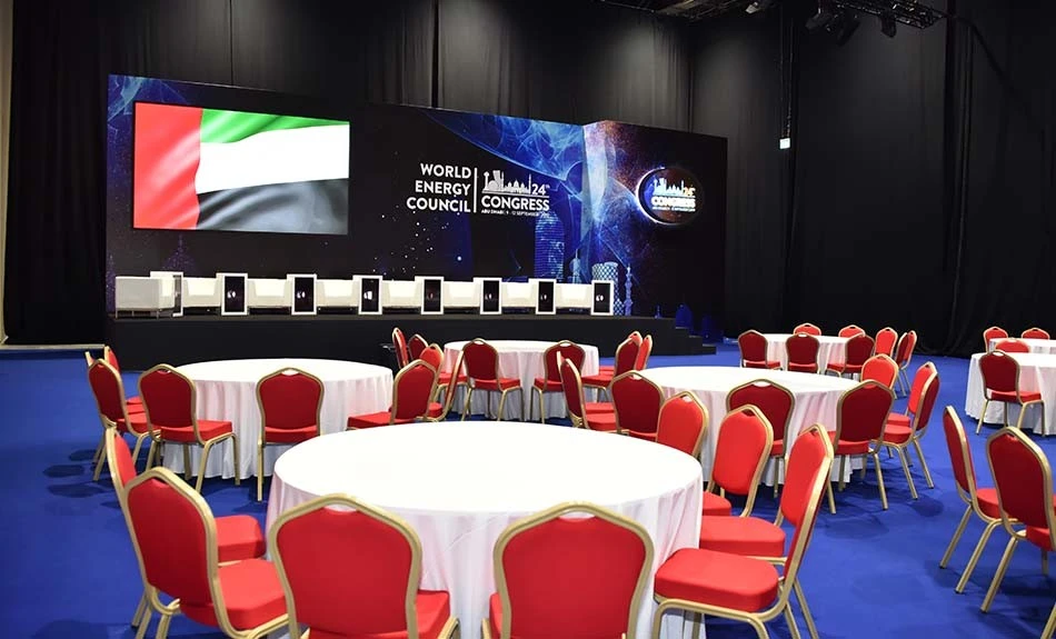 ADNEC Centre Abu Dhabi event setup with round tables and stage.