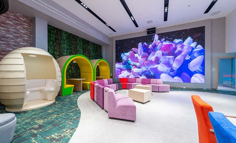 Colorful seating area at ADNEC Centre Abu Dhabi with large screen.