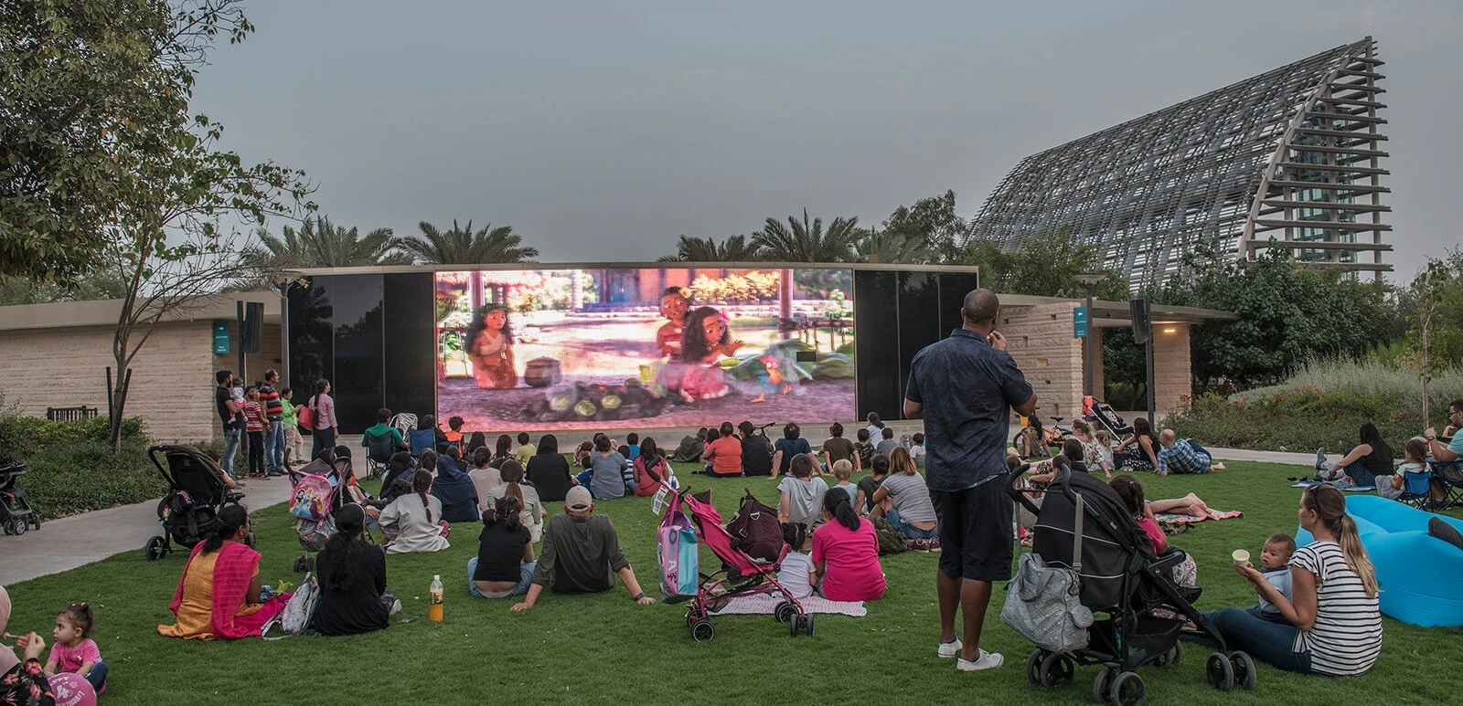 Families watching outdoor movie at Umm Al Emarat Park, Abu Dhabi.