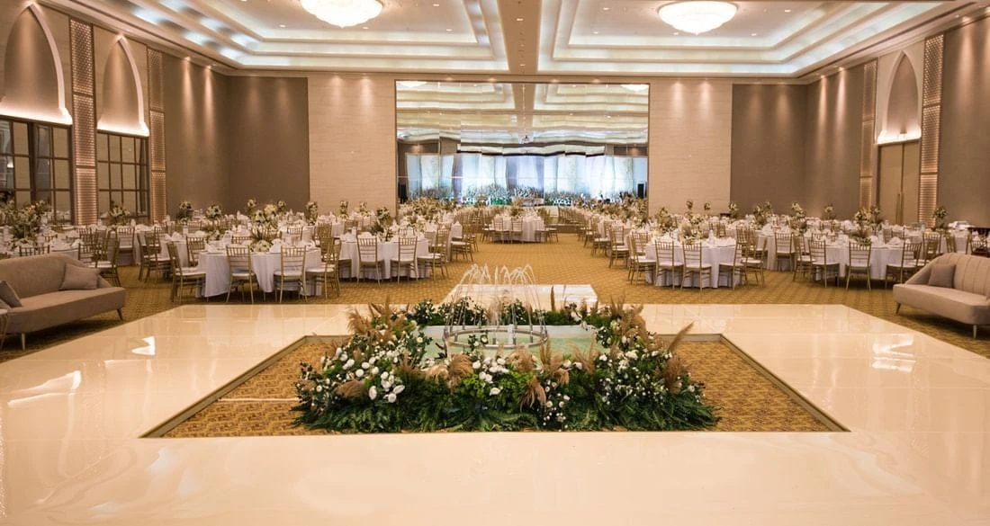 Elegant banquet hall at Kempinski Hotel Ajman with decorated tables.
