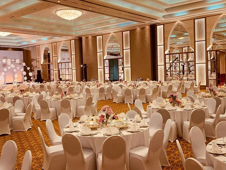 Elegant ballroom setup at Kempinski Hotel Ajman, featuring round tables.