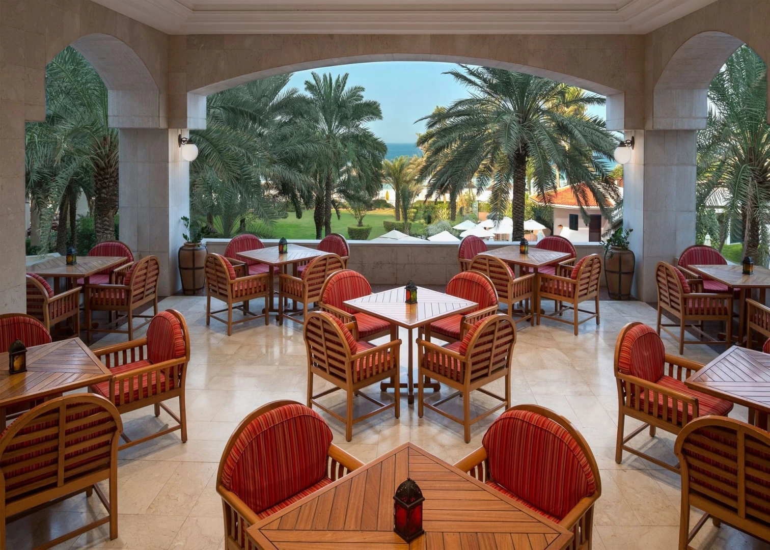 Terrace seating with palm trees at Kempinski Hotel Ajman.