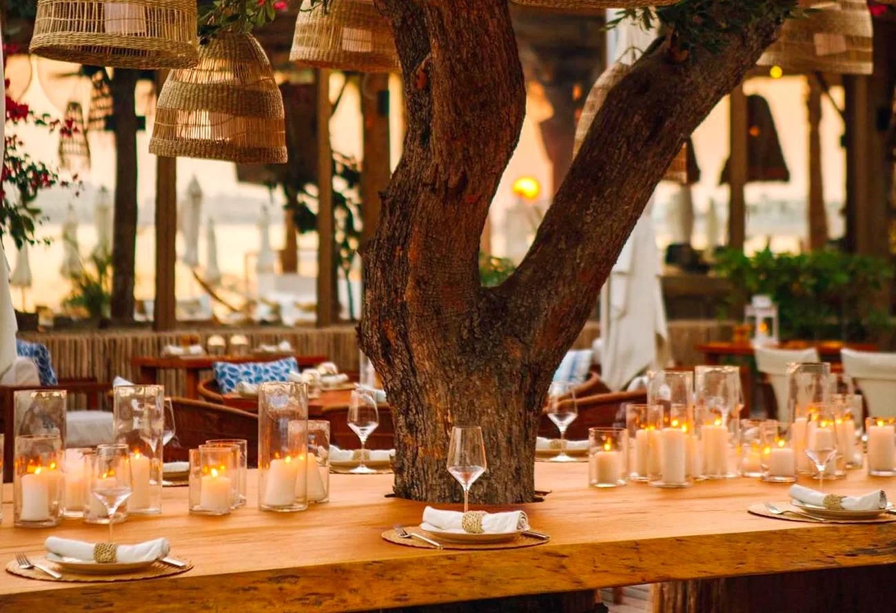 Elegant dining setup at Surf Club Dubai with candles and tree.